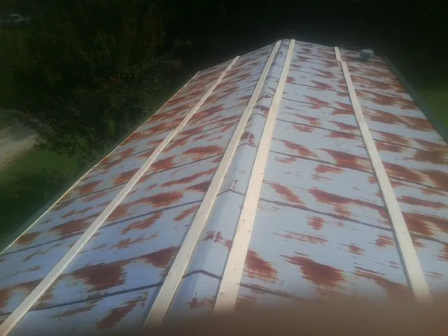 Rusted metal roof panels with new wood purlins before replacement — Storm Damage Roof Repair in Moundville by Roofing Brothers