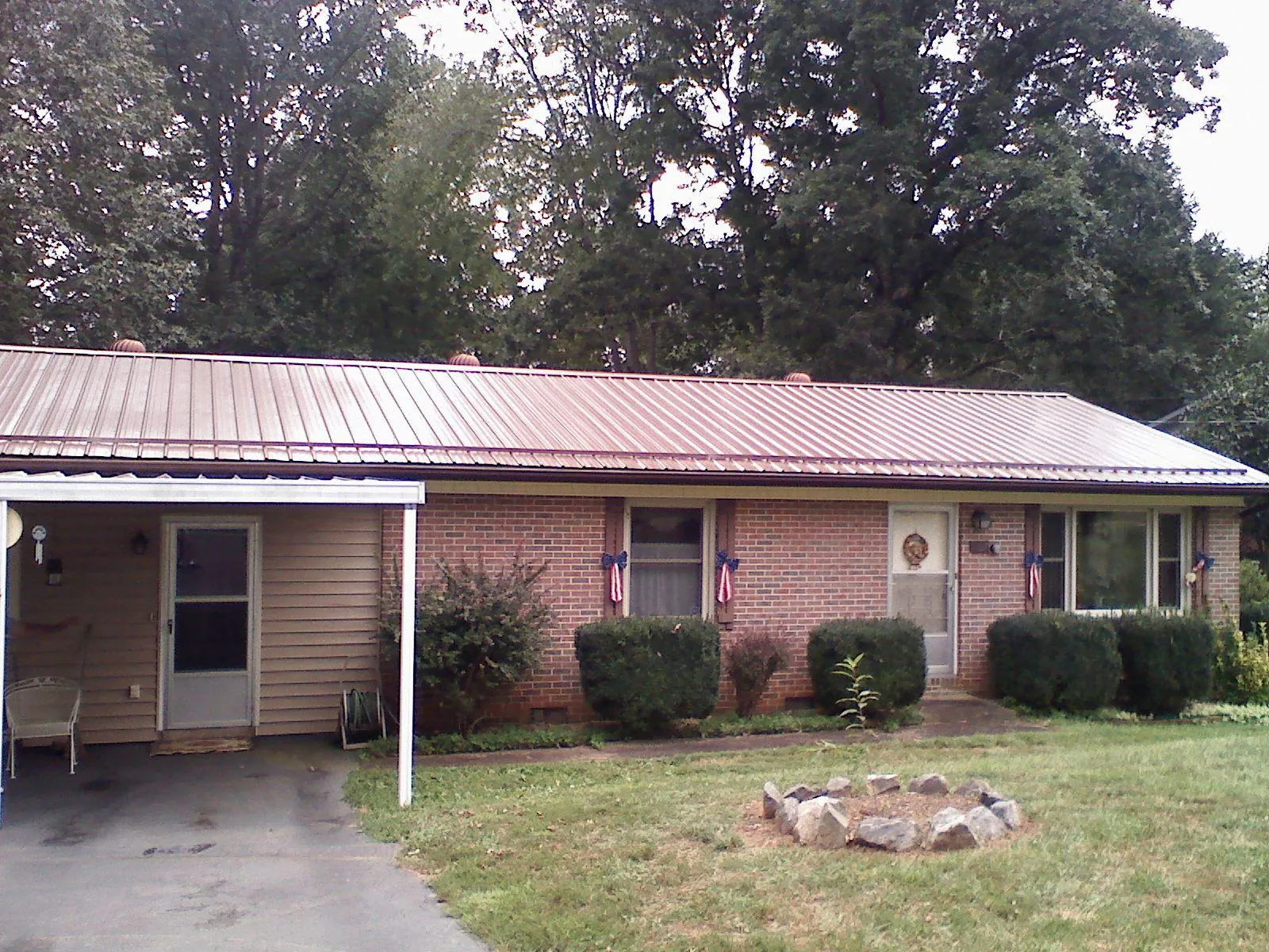 Bronze metal roof and carport on a brick ranch home — Roof Repair work by our crew in Moundville