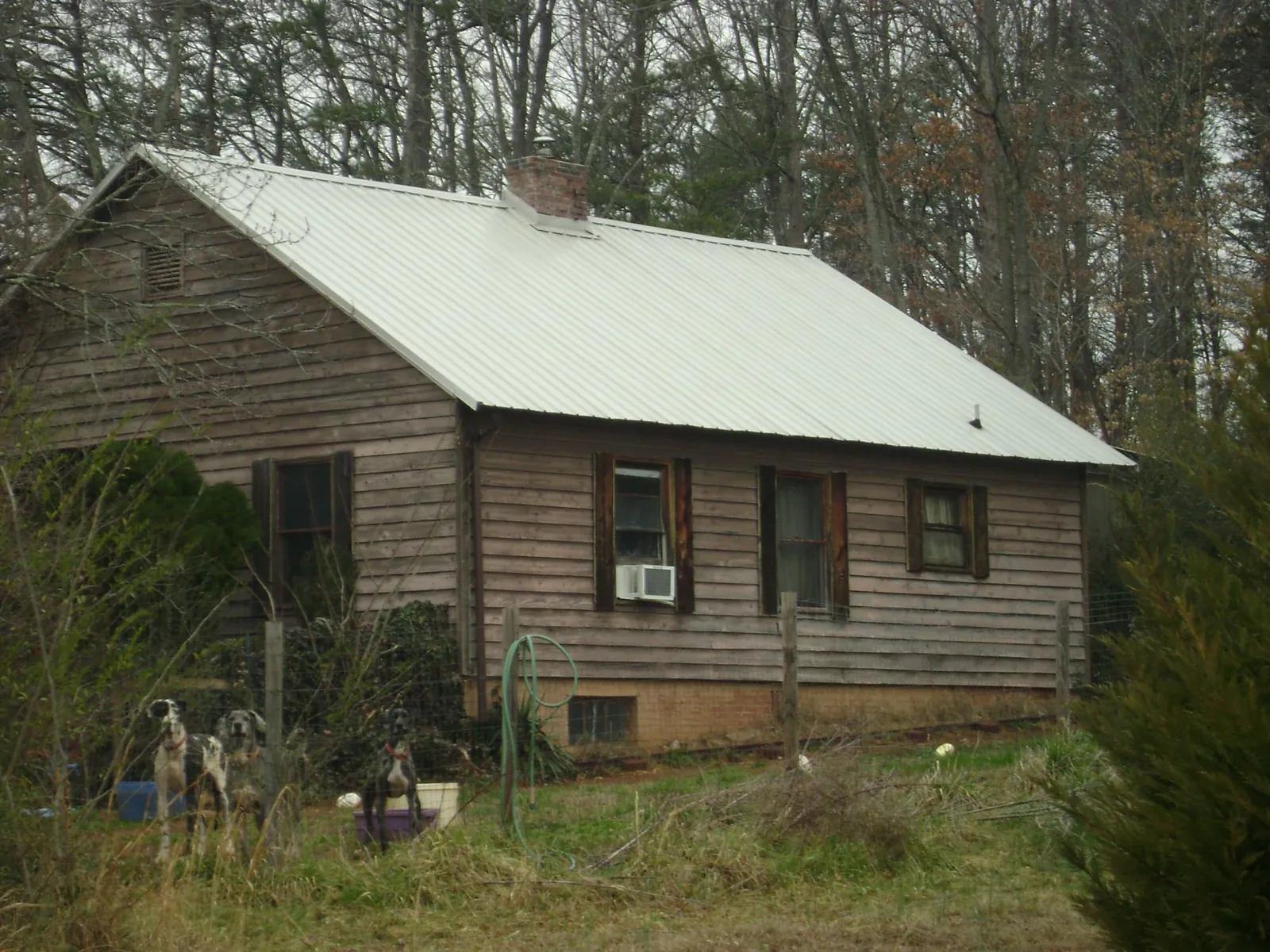 White metal roof on an old wood sided farmhouse, from a Asphalt Shingle Roof Repair job in Moundville